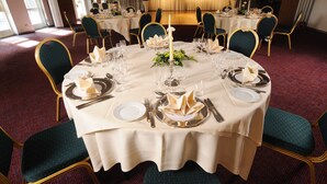 A banquet hall with round tables set for a formal event, featuring gold chairs and white tablecloths. - Vildbjerg Hotel (Vildbjerg)