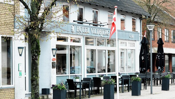 Hotel Vildbjerg with outdoor seating and a flag. - Vildbjerg Hotel (Vildbjerg)