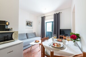Apartamento tradicional, 1 quarto, para não fumantes, no piso térreo | Área de estar | TV de tela plana 82 cm com canais a cabo, TV