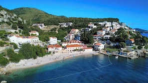 A coastal town with buildings on a hillside overlooking a beach. - Villa Doris (Dubrovnik)