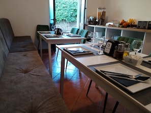 A dining area with a sofa, two tables, and a kitchen counter with various items. - Villa Doris (Dubrovnik)