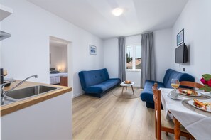 Apartamento clássico, 1 quarto, terraço, vista parcial para o mar | Área de estar | TV de tela plana 82 cm com canais a cabo, TV