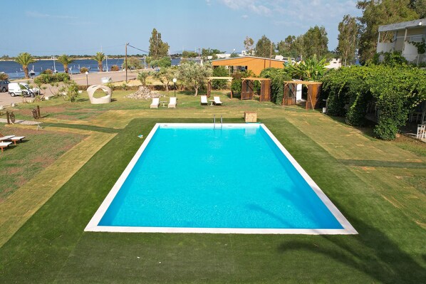 Una piscina al aire libre de temporada, sombrillas