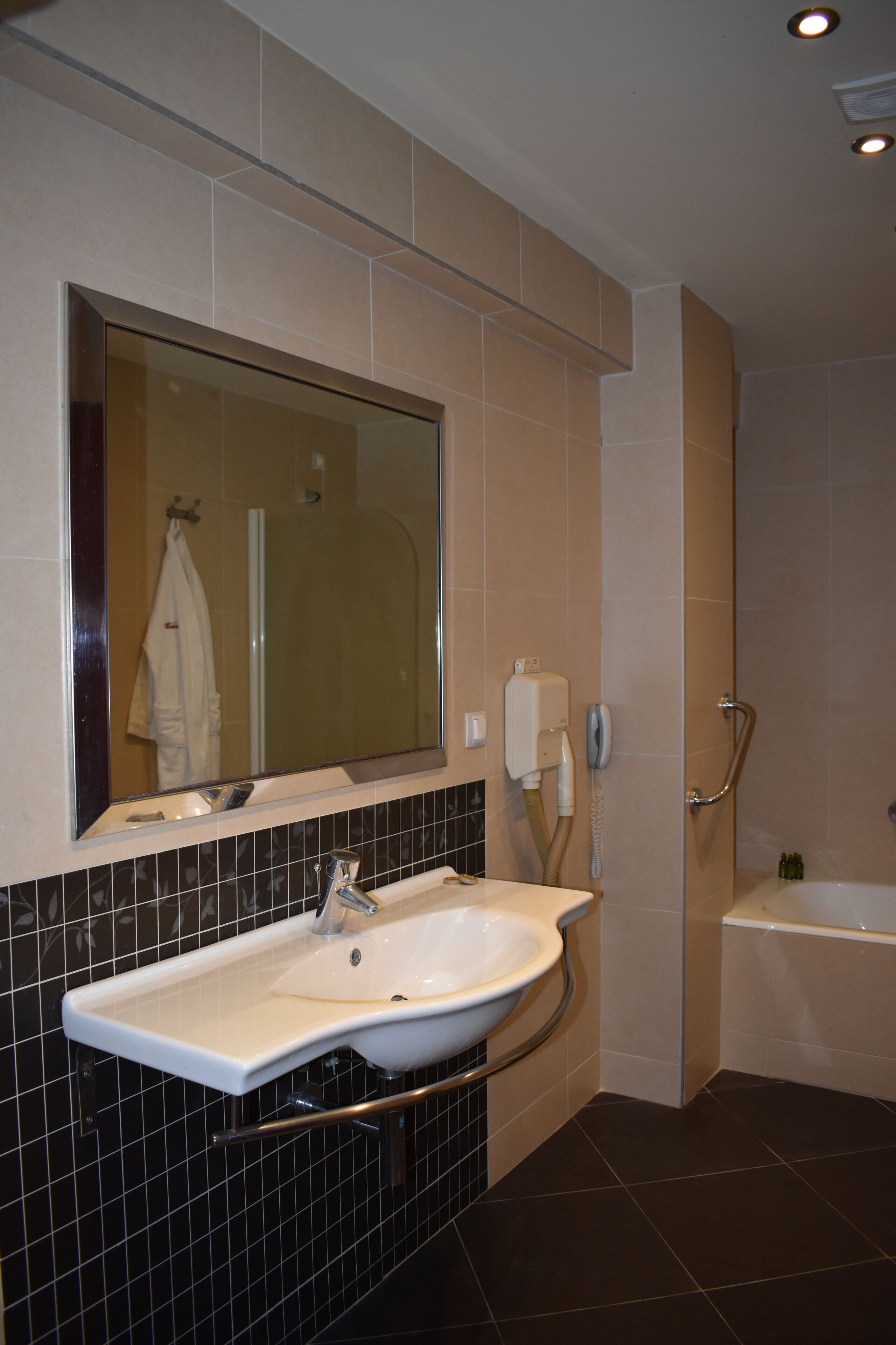 A bathroom with a large mirror, a sink, a shower, and a bathtub.