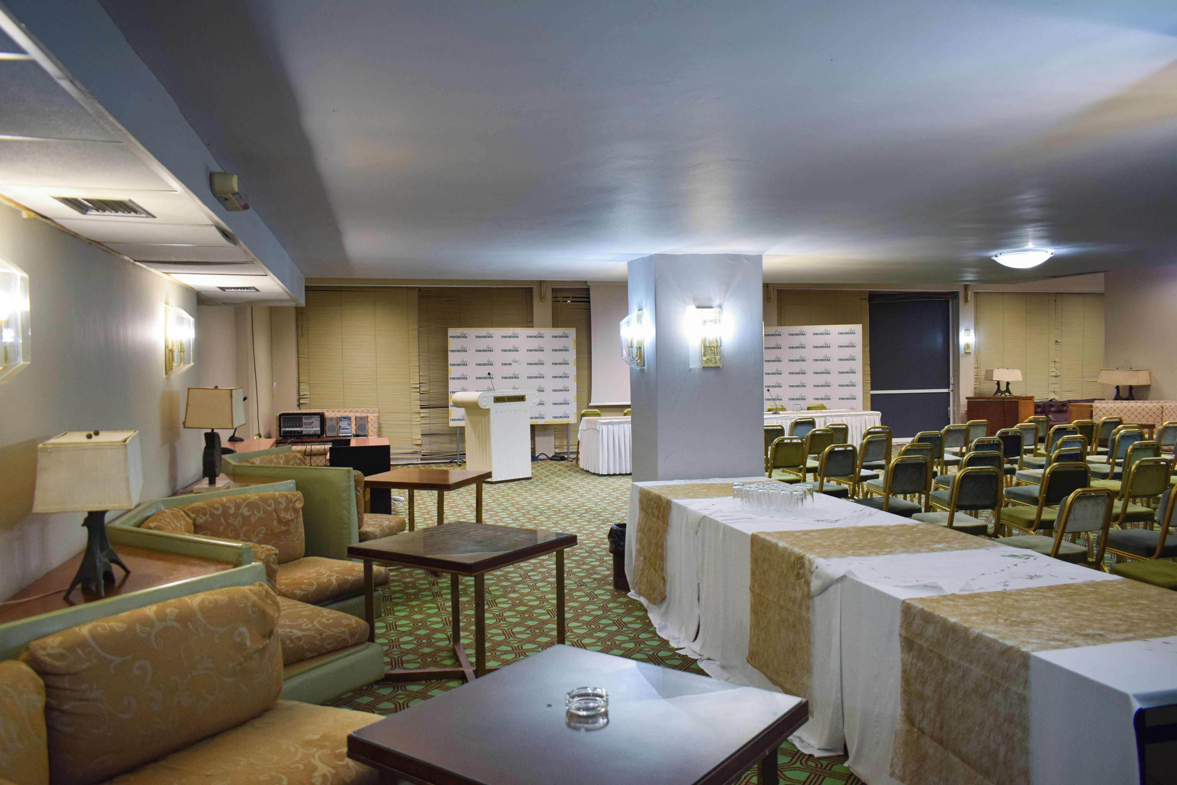 A hotel room with a seating area, a table, and a television.