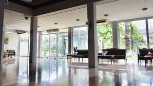 A spacious lobby with a polished floor, large windows, and seating areas. - Theoxenia (Mesolongi)