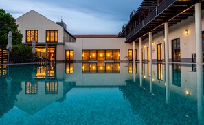 Una piscina cubierta, una piscina al aire libre, tumbonas