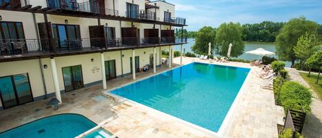 Alberca techada, alberca al aire libre y camastros