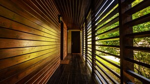 A wooden corridor with a bench and a door at the end. - Tisza Balneum Thermal Hotel (Tiszafured)