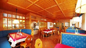 A restaurant with wooden interior, booths, and tables. - Salzburger Dolomitenhof (Annaberg-Lungoetz)