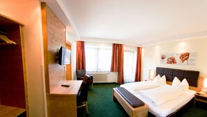 A hotel room with a bed, a desk, a chair, a television, and a painting on the wall. - Salzburger Dolomitenhof (Annaberg-Lungoetz)