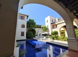 A courtyard with a pool, white buildings, and arches. - Hotel Boutique La Casa Azul (Cuernavaca)