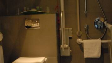 Une salle de bain équipée de toilettes, d’une douche et d’un porte-serviettes.