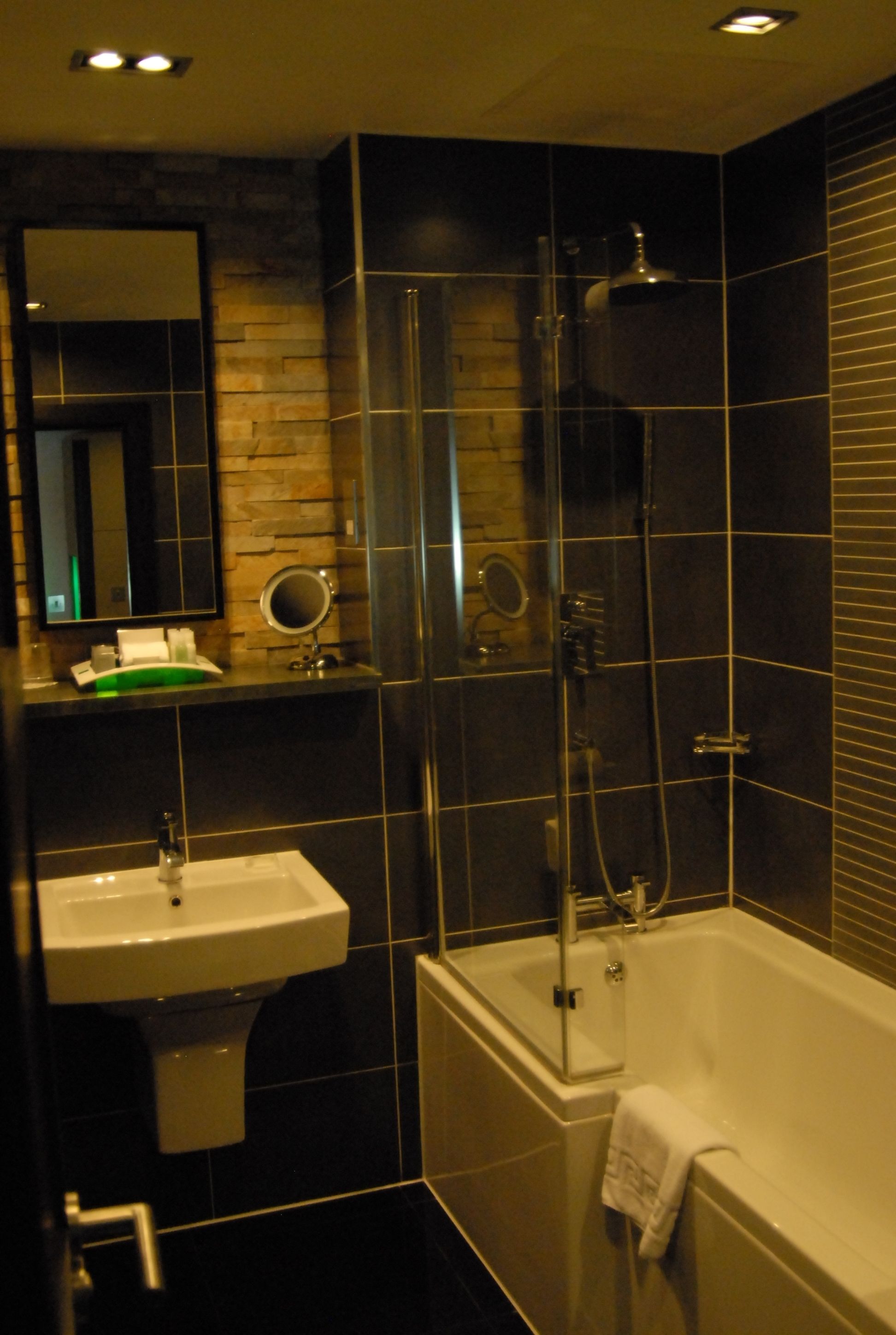 A modern bathroom with a bathtub, a sink, and a mirror.