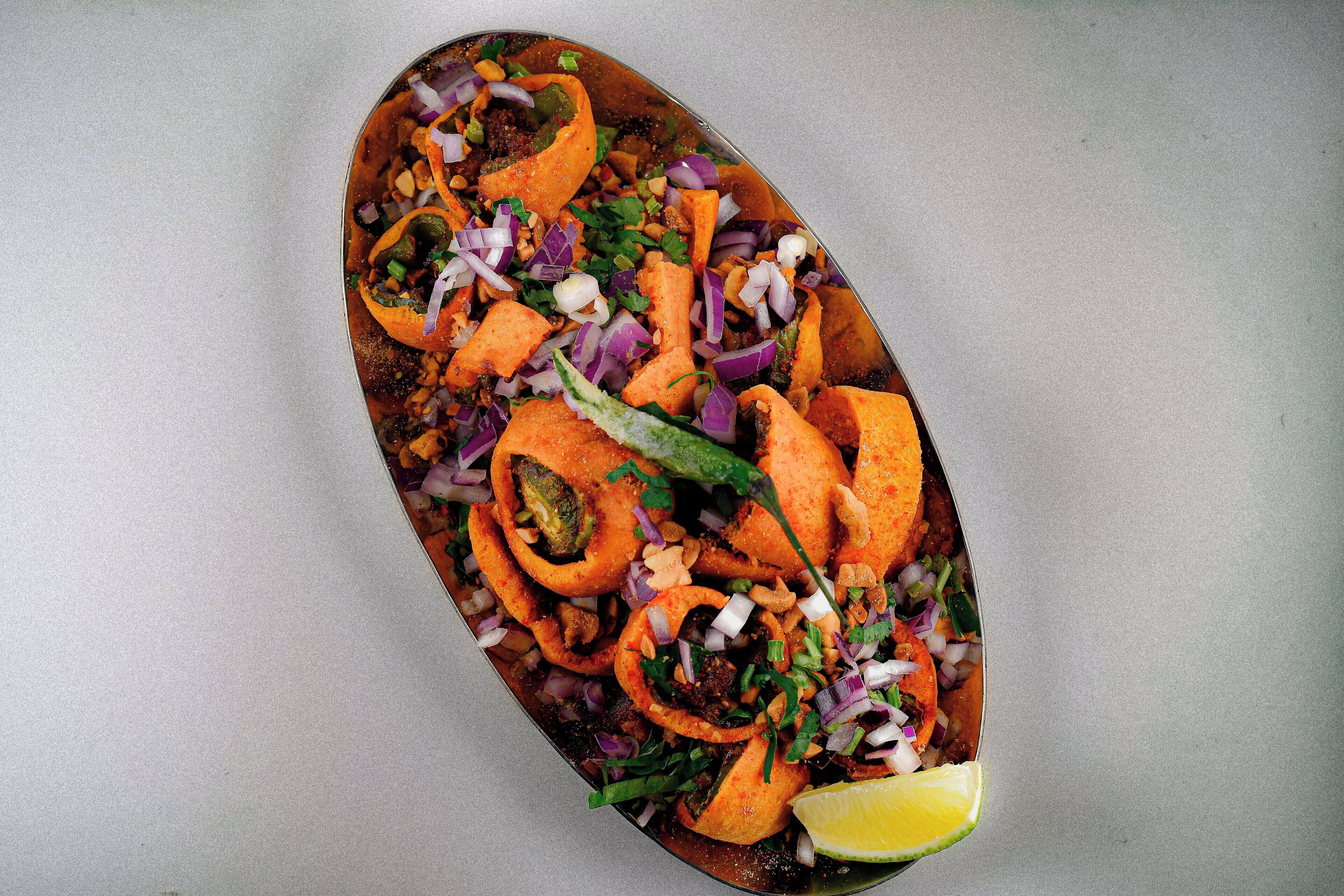 Un plato con vegetales en rodajas y una cuña de lima.