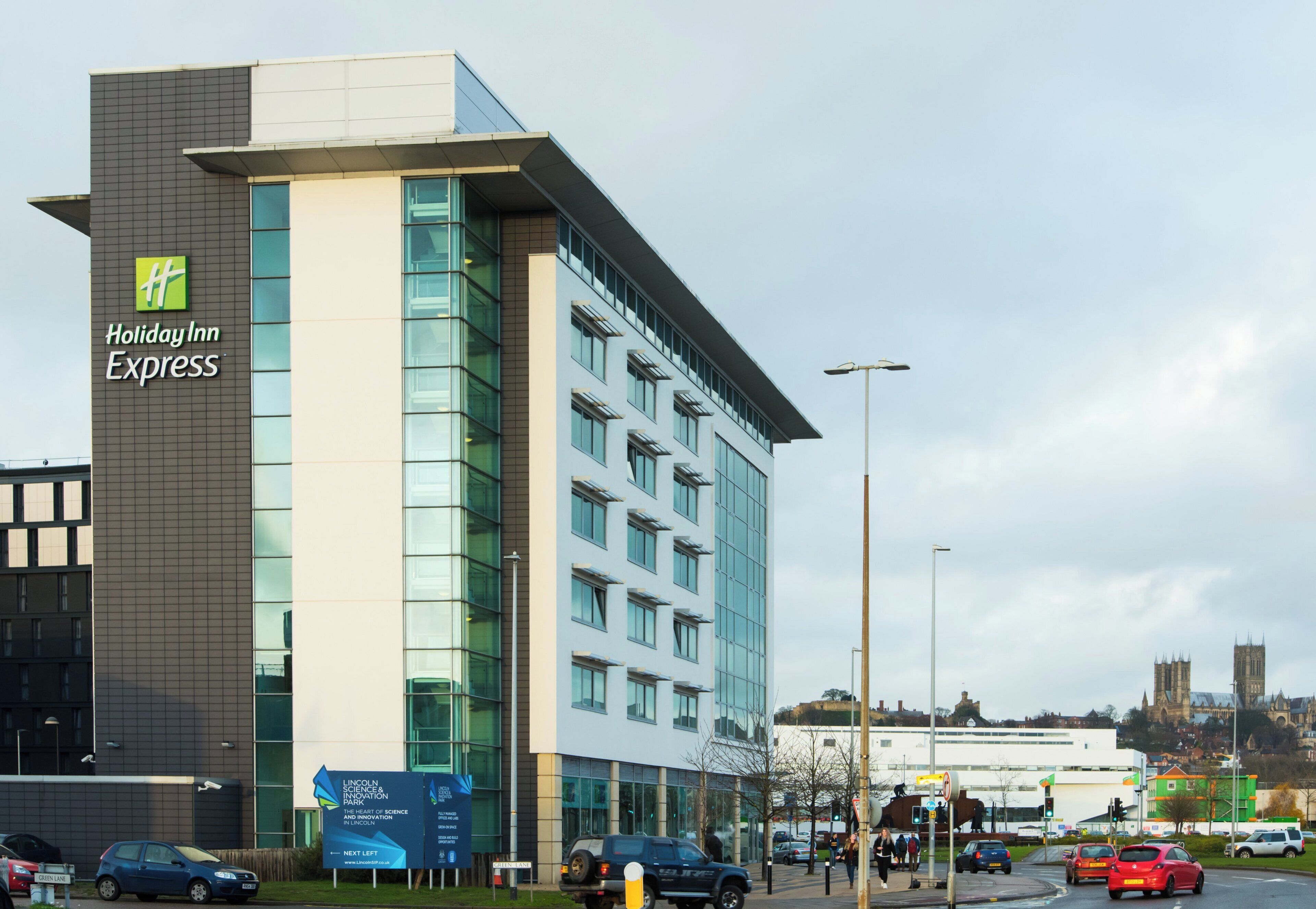 Um hotel Holiday Inn Express com design moderno, apresentando uma placa chamativa na fachada.