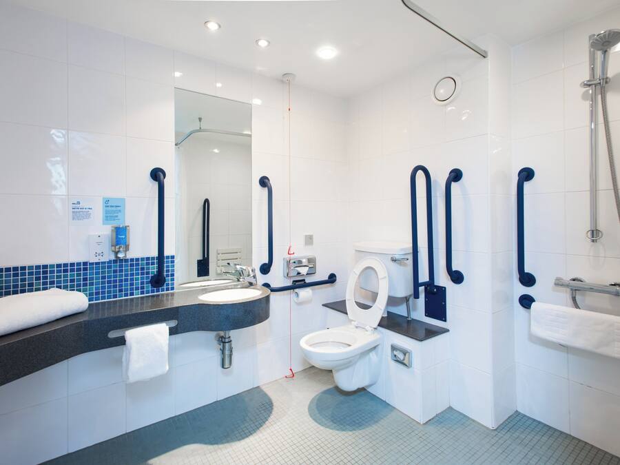 A modern bathroom with a sink, toilet, and shower.