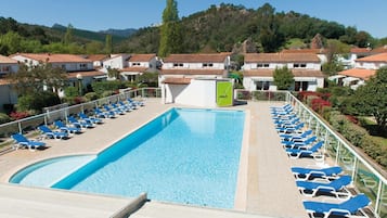 Una piscina al aire libre de temporada, sombrillas