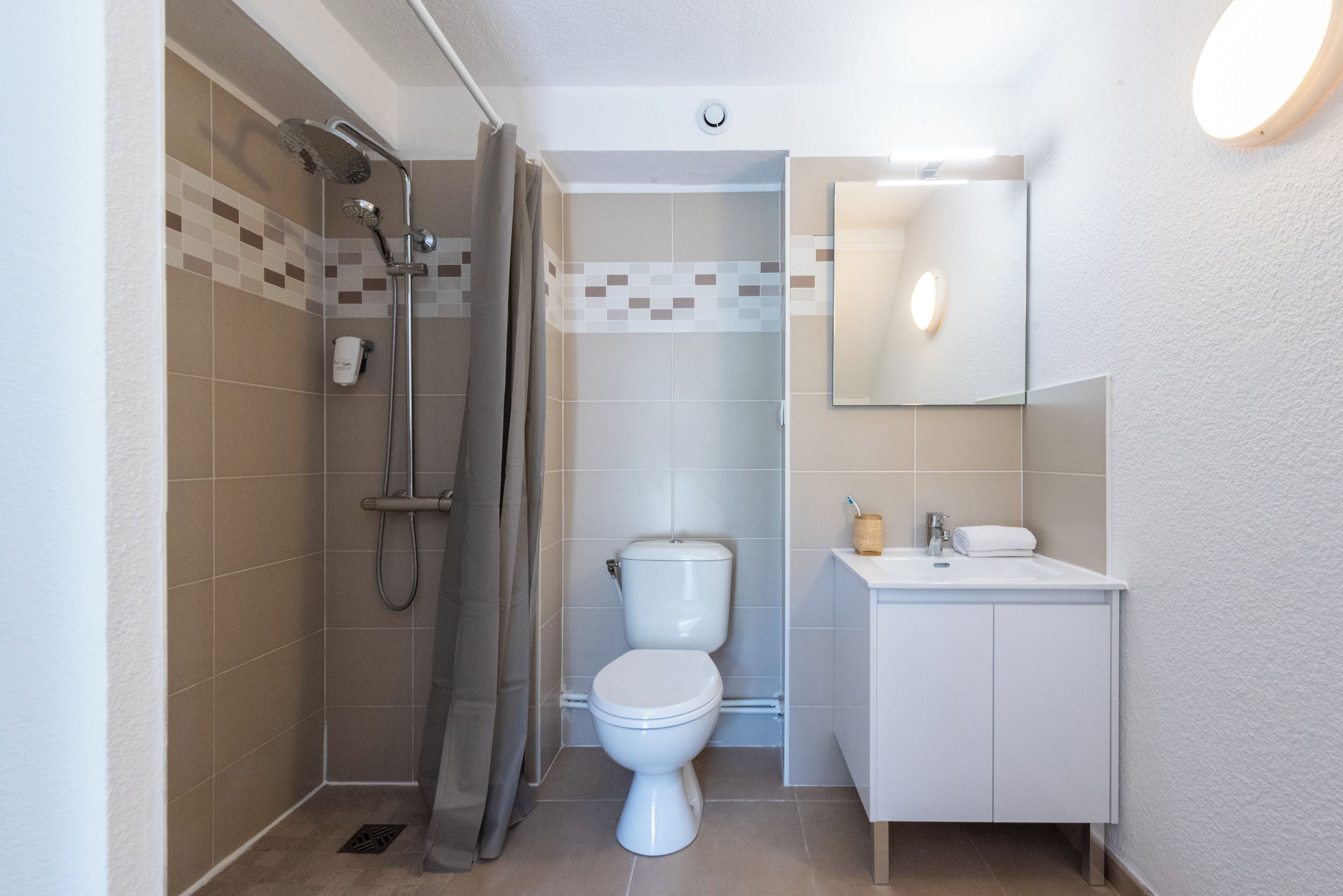 A bathroom with a shower, toilet, and sink.
