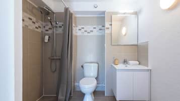 A bathroom with a shower, toilet, and sink.