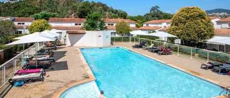 Alberca al aire libre por temporada y sombrillas en la alberca