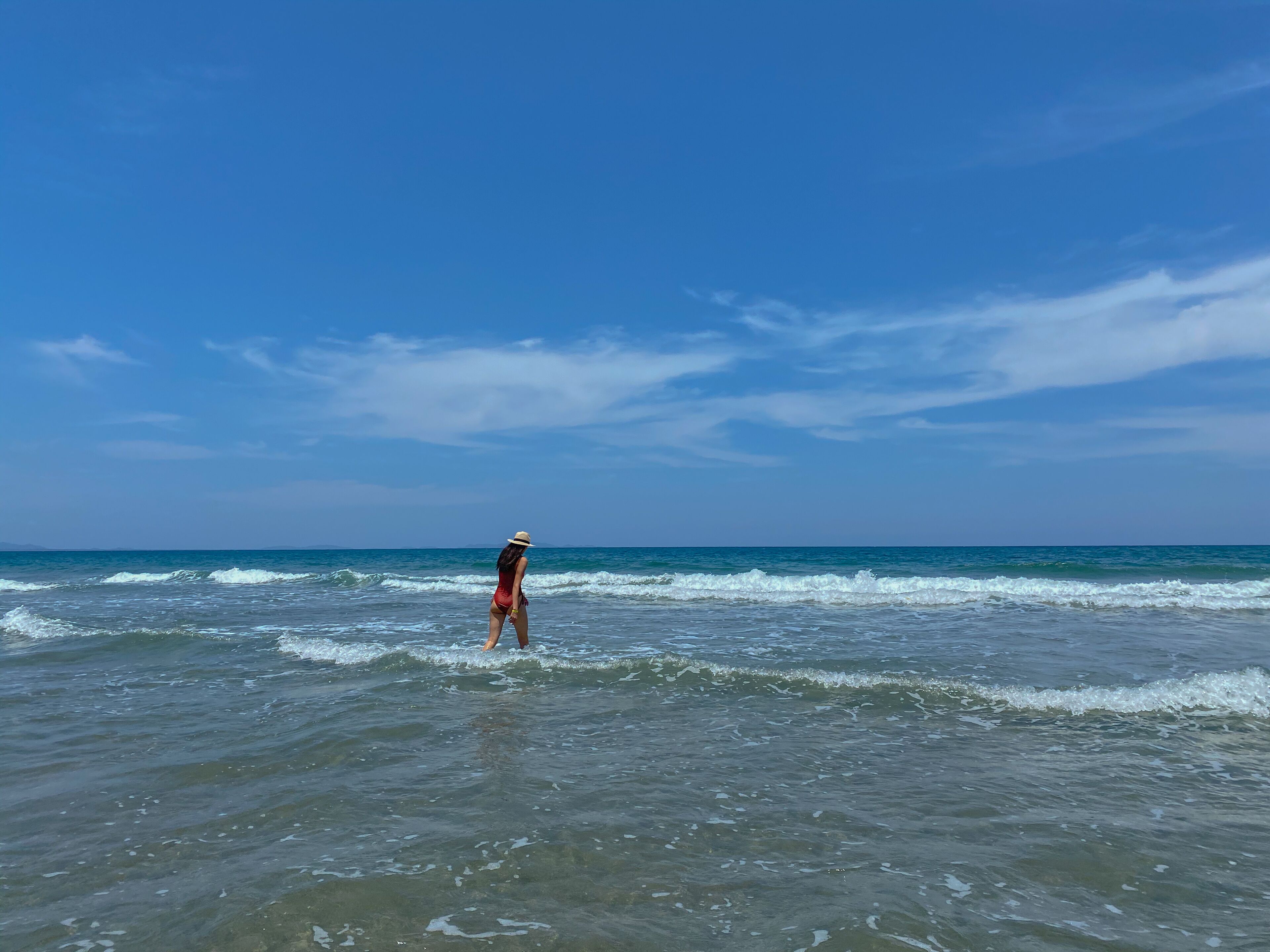 Una persona de pie en aguas poco profundas en la playa.
