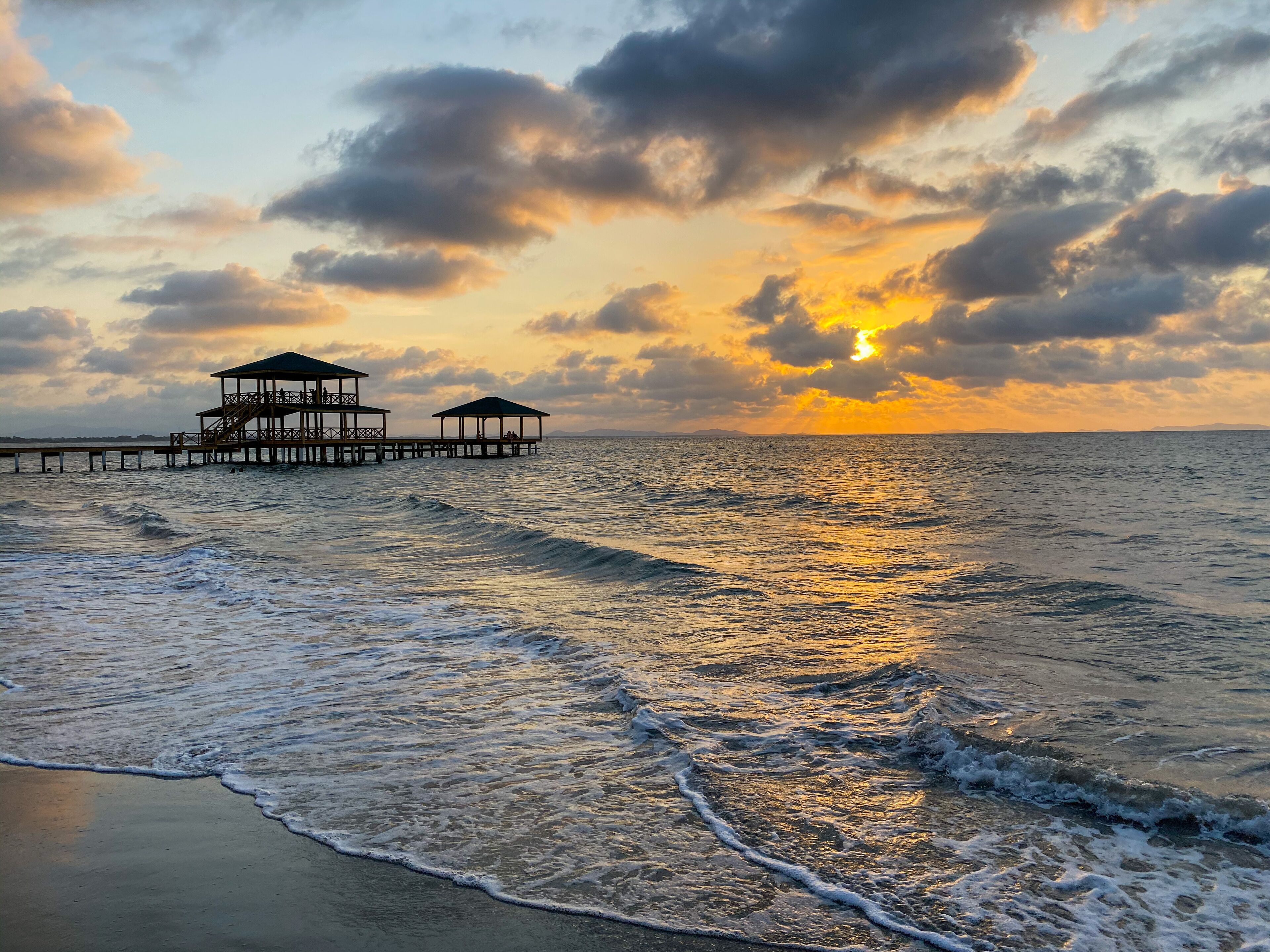 Na praia, areia branca, espreguiçadeiras, guarda-sóis 