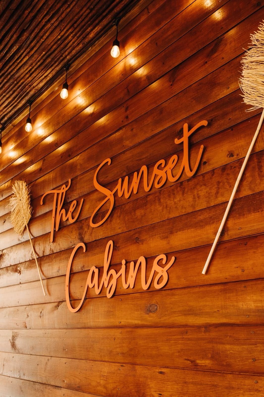 A wooden wall with the text 'The Sunset Cabins' and a decorative broom.