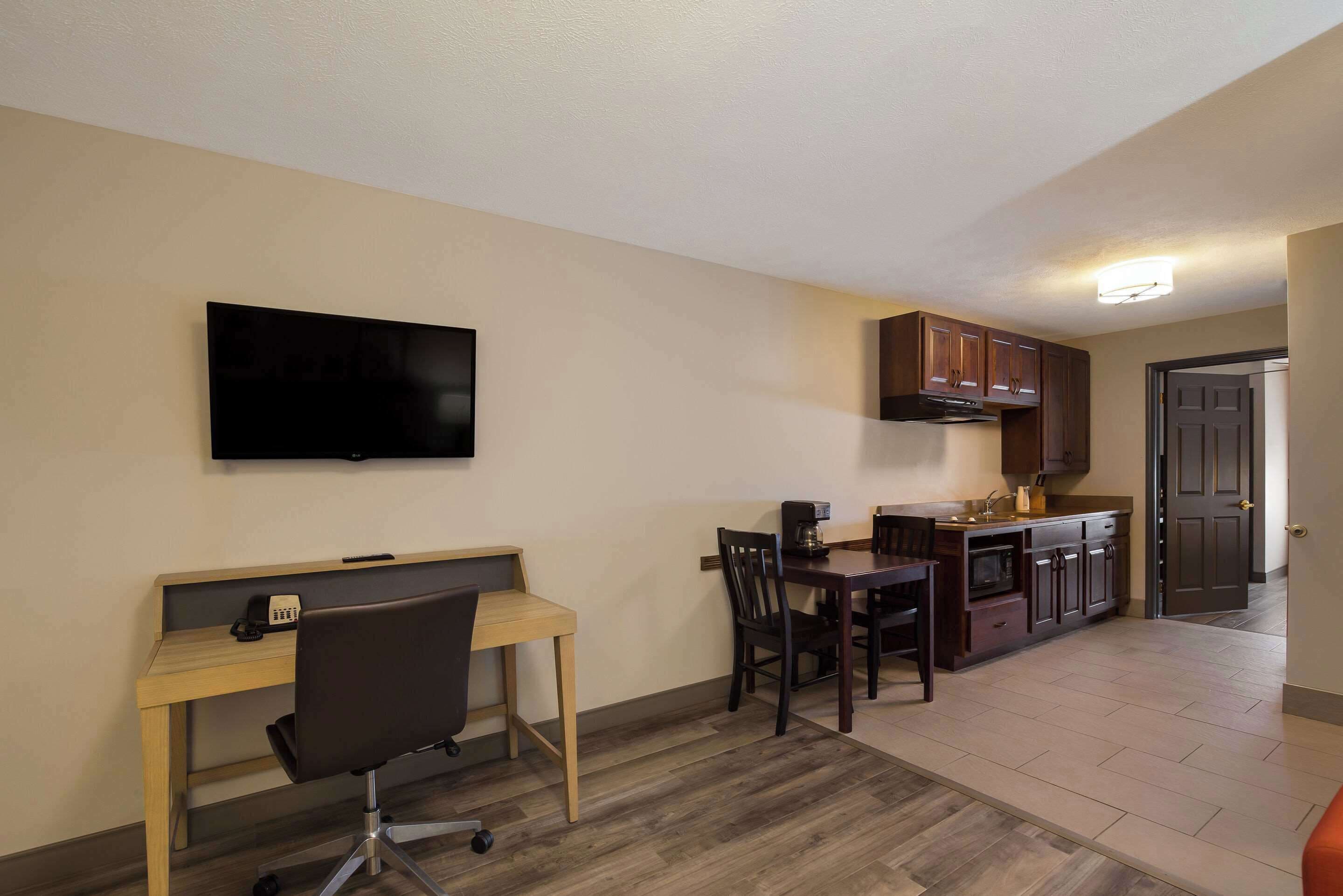 A compact living space with a kitchenette, a dining area, and a workspace.