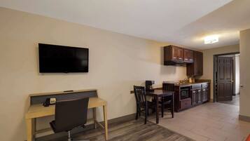A compact living space with a kitchenette, a dining area, and a workspace.