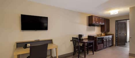 A compact living space with a kitchenette, a dining area, and a workspace.
