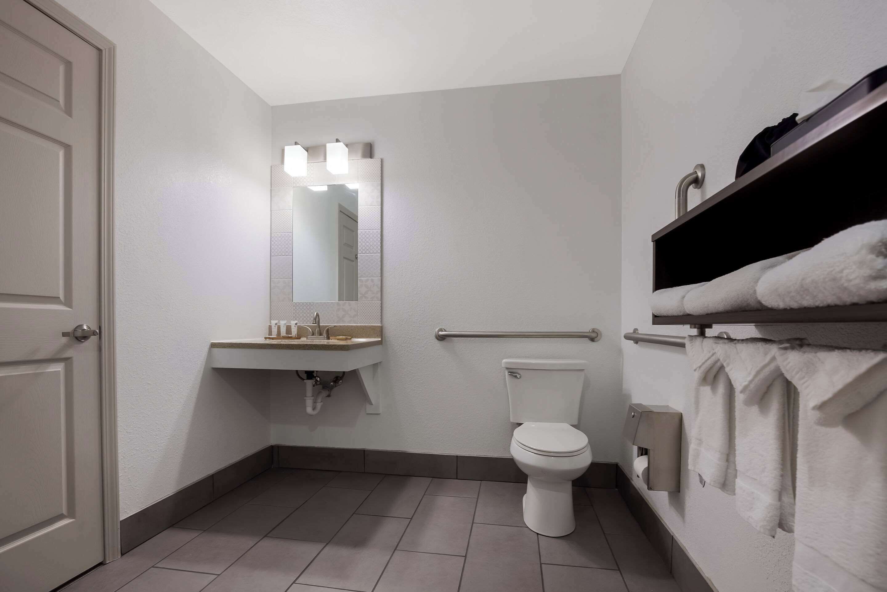 Un baño con inodoro, lavabo y barra para toallas.