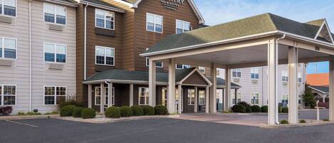 Een Country Inn & Suites gebouw met een overdekte ingang en een parkeerplaats.