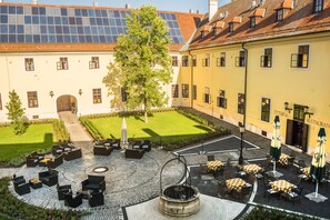 Une cour dotée d’un espace extérieur aménagé avec des sièges, une fontaine et un restaurant appelé « Ettrem ».