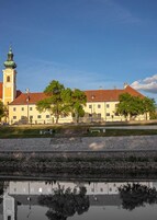 A historic building with a prominent tower and a reflection in the water.