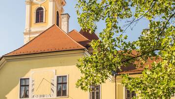 A yellow building with a clock tower and a green dome.