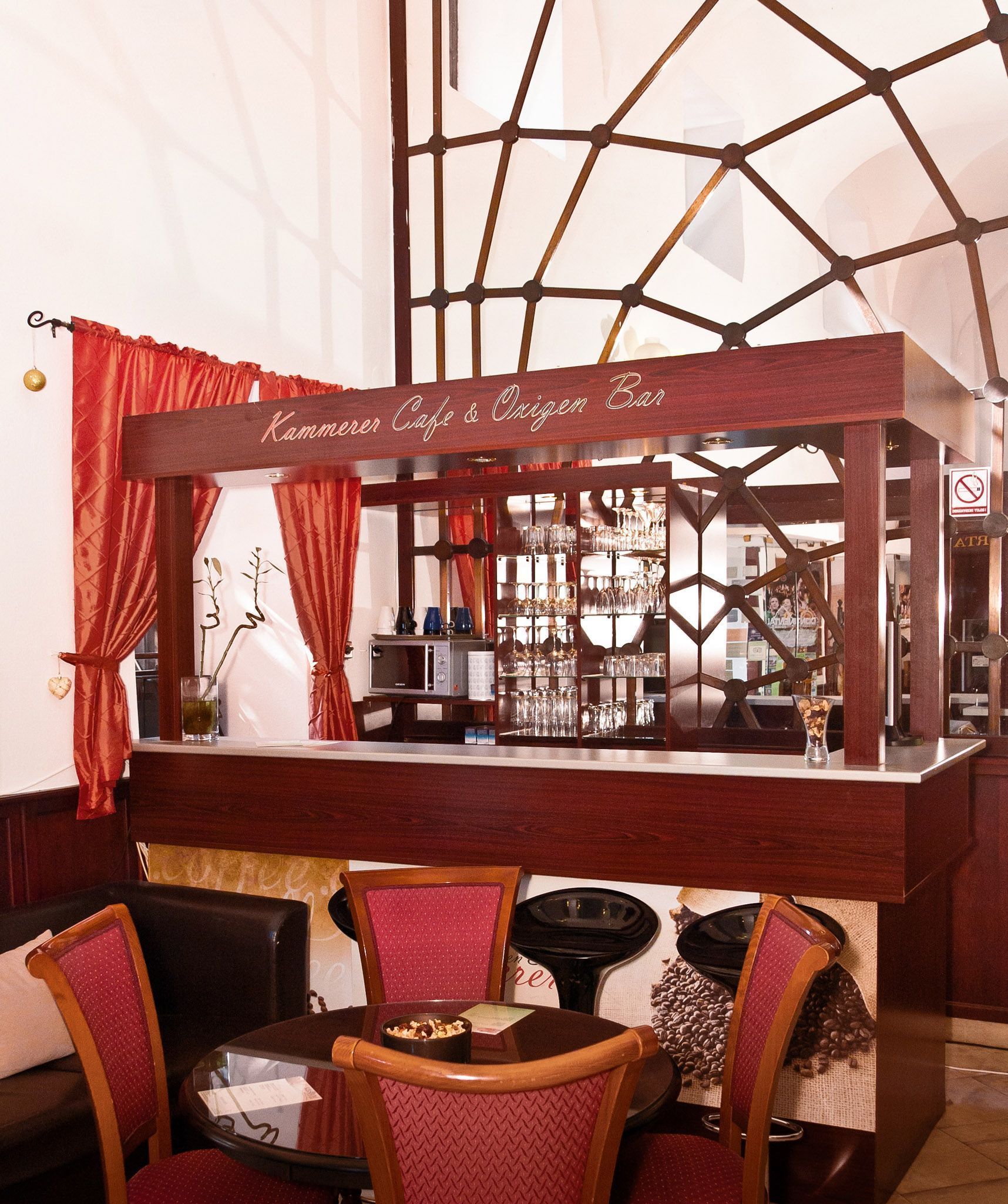 Eine Bar mit einem Schild, auf dem "Kammerer Cafe & Oxygen Bar" steht, mit einer Bar, Stühlen und einer Glasvitrine.