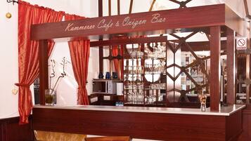 Eine Bar mit einem Schild, auf dem "Kammerer Cafe & Oxygen Bar" steht, mit einer Bar, Stühlen und einer Glasvitrine.