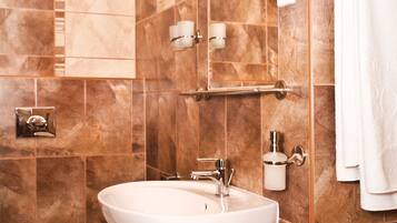 A bathroom with a sink, toilet, and towel rack.
