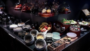 A buffet with various food items and containers, including fruits, vegetables, and condiments. - Hotel AMANO Rooms & Apartments (Berlin)