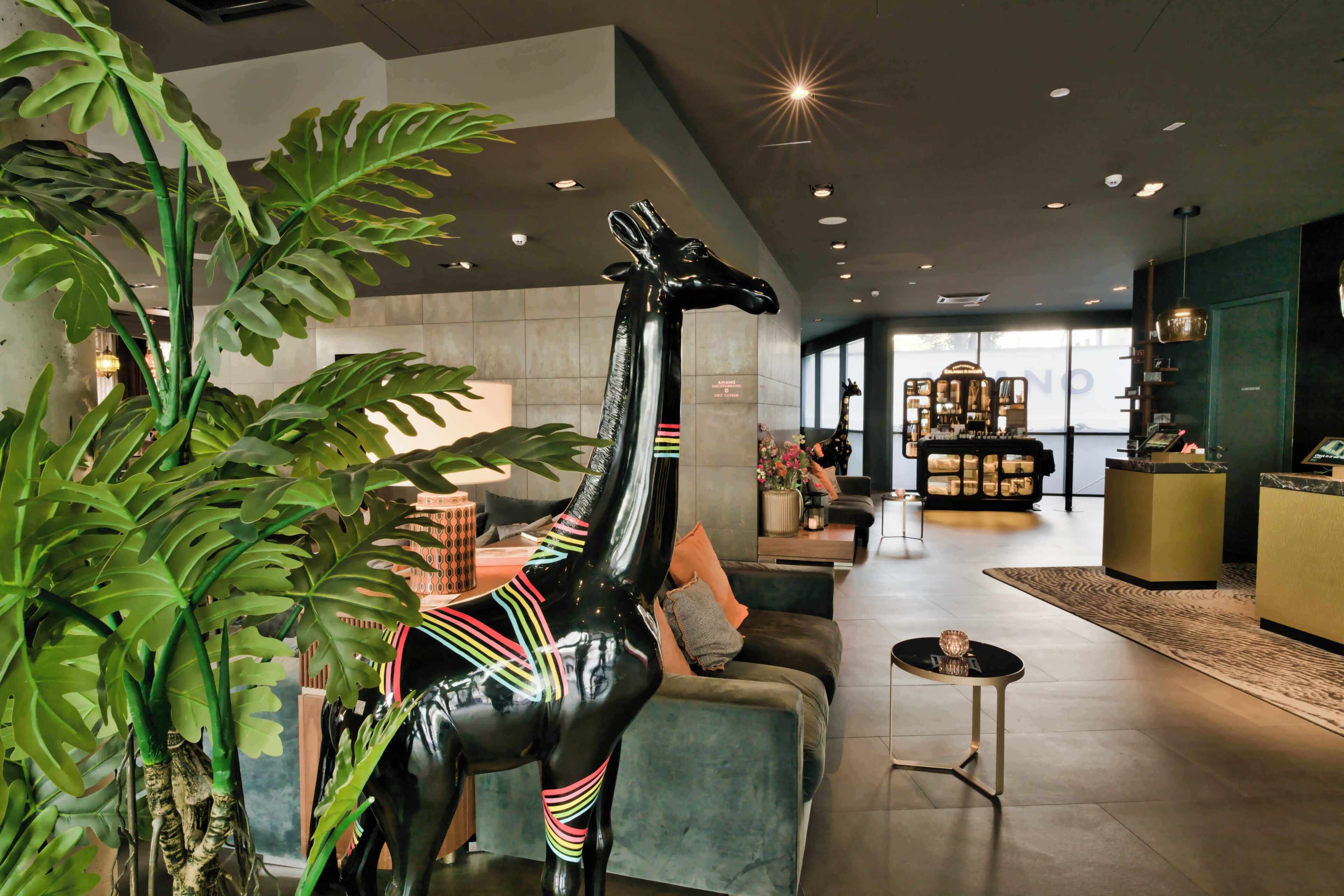 Un intérieur moderne agrémenté d’une statue de girafe, d’un comptoir d’accueil et d’un espace détente.