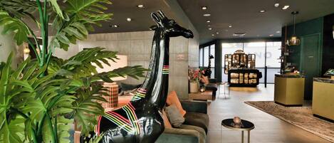Un intérieur moderne agrémenté d’une statue de girafe, d’un comptoir d’accueil et d’un espace détente.