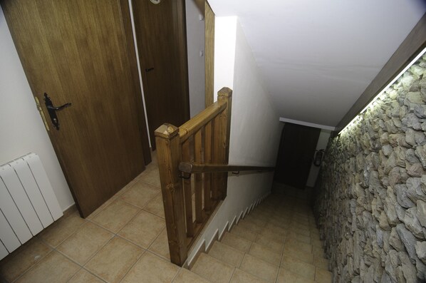 A wooden door with a metal handle, a white radiator, and a stone wall. - L'Era De Cal Bastida - Guest House (Estamariu)