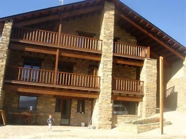 A multi-story stone building with wooden balconies.