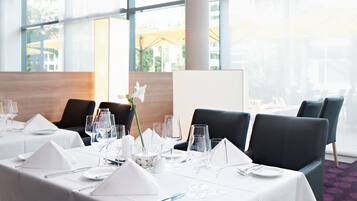 Ein Konferenzraum mit langem Tisch, gedeckt für eine Besprechung, großen Fenstern und Blick ins Freie.