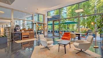 Un interior moderno con una zona de estar, ventanas amplias y vistas al exterior.