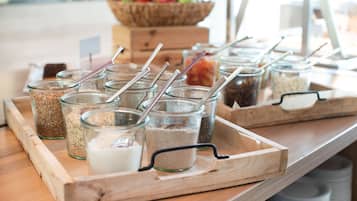 A wooden tray with glass jars containing various food items and utensils.
