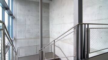 Ein modernes Interieur mit Betongböden, Metallgeländern und einer Treppe.