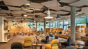 A spacious lounge area with multiple seating options, including sofas and chairs, arranged around a central coffee table. - Seminaris CampusHotel Berlin (Berlin)
