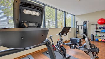 Kotikuntosali, jossa on kuntopyörä, crosstrainer ja jumppapalloja.